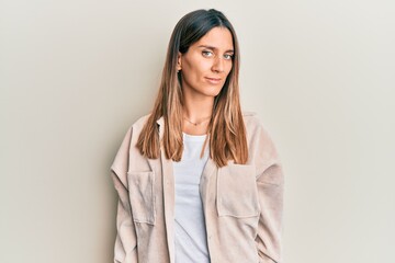 Brunette young woman wearing casual clothes relaxed with serious expression on face. simple and natural looking at the camera.