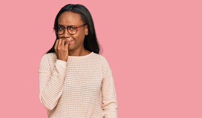 Young black woman wearing casual clothes and glasses looking stressed and nervous with hands on mouth biting nails. anxiety problem.