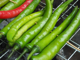 Young green chilli grill on Grill grate before cooking Northern Thai Green Chilli Dip, Called "Nam Prik Num", Selective focus.