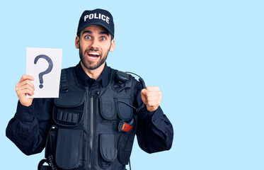 Young handsome man with beard wearing police uniform holding question mark screaming proud, celebrating victory and success very excited with raised arms