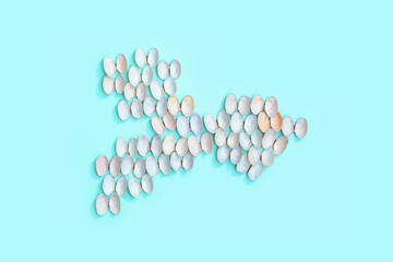 Fish shape from natural seashells on blue paper. Summer design concept with shells