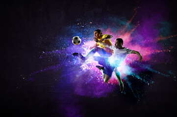 Boys playing soccer hitting the ball