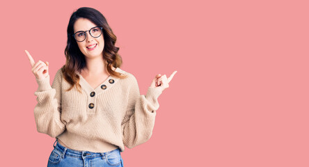 Beautiful young brunette woman wearing casual clothes and glasses smiling confident pointing with fingers to different directions. copy space for advertisement