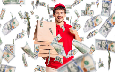 Young handsome man with curly hair holding delivery pizza box smiling happy and positive, thumb up doing excellent and approval sign