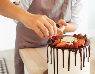 Obraz na płótnie Canvas Chef decorate the cake wild berries