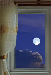 White full moon and clouds in the window view at night