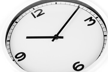 Close up diagonal black and white analog clock over a white background