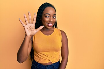 Young african american woman wearing casual clothes showing and pointing up with fingers number five while smiling confident and happy.