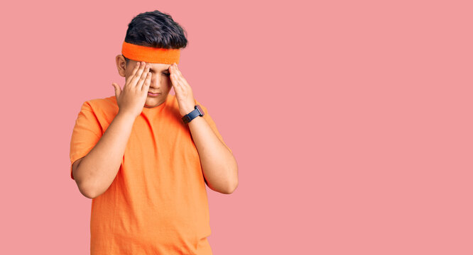 Little boy kid wearing sportswear with hand on head, headache because stress. suffering migraine.