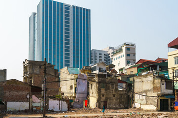 Ruin houses on highrise building background contrast on Minh Khai street, Hanoi, Vietnam