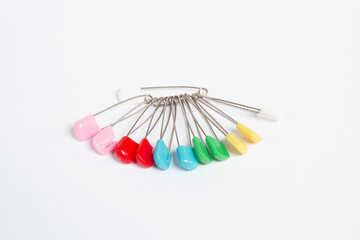 Colored sewing pins on white background