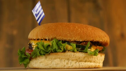 Delicious burger with small Greek flag on top of them with toothpicks. Yummy hamburger rotating. - Powered by Adobe