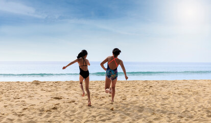 Stop motion happy two children wear swimwear running from beach to the sea. Happy family holiday summer concept. Two girl running to beach