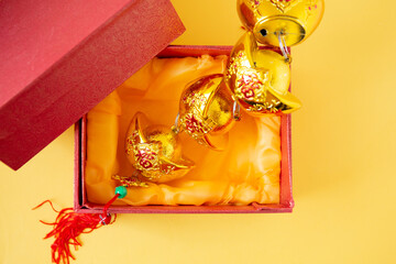 Lunar New Year decoration with lucky gold bar isolated on yellow . Tet Holiday.Translation of text appear in image: fortune good luck