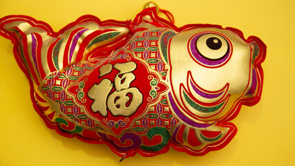 Translation of text appear in image: fortune good luck. Lucky Red Fish - Lunar New Year Decoration , Vietnamese Tet Holiday top view isolated on yellow background