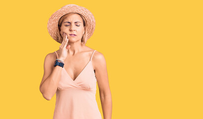 Young blonde woman wearing summer hat touching mouth with hand with painful expression because of toothache or dental illness on teeth. dentist