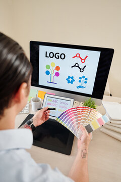 Graphic Designer With Color Palette In Hands Creating Company Logo