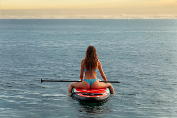 girl swims on a surfboard