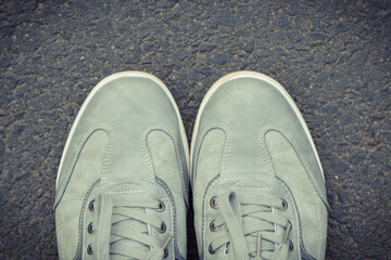 Gray leather shoes on asphalt road or footpath. Male footwear