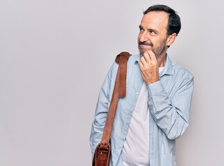 Middle age handsome businessman wearing leather bag over isolated white background thinking concentrated about doubt with finger on chin and looking up wondering