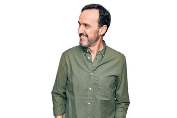 Middle age handsome man wearing casual green shirt over isolated white background looking to side,...