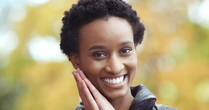 Close-up of afro female contented happy face. Portrait of positive african american girl black woman smiling toothy laughing looking at camera standing posing isolated hands folded in favor of request