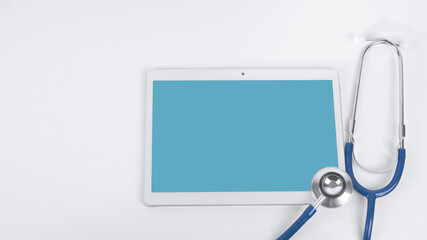 White tablet and stethoscope on a colored background. Online medical support concept.