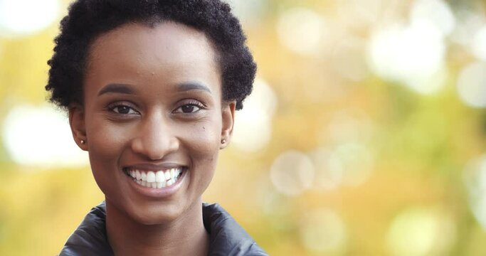 Portrait african american girl mixed race black woman teenager lady ethnic wife standing outdoors in city smiling wide toothy with contented joyful facial expression with good mood looking at camera