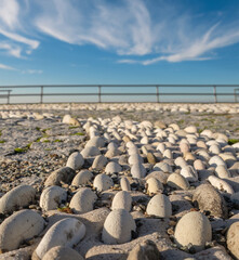 Obraz premium Decorative pebble stone path with blurred background of railing and blue sky