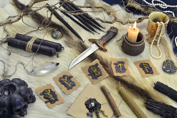 Fototapeta na wymiar Still life with runes, ritual knife and black candles on witch table.