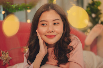 Portrait of happy asian woman in christmas decorated room indoors.