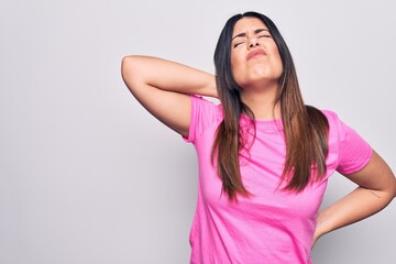 Young beautiful brunette woman wearing casual pink t-shirt standing over white background Suffering of neck ache injury, touching neck with hand, muscular pain