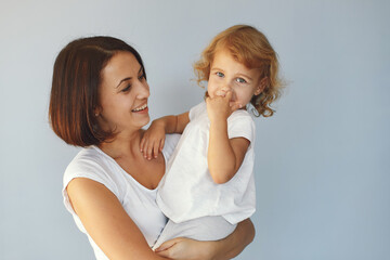 Beautiful woman with child. Woman in a white t-shirt. Family on a blue backgroung