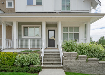 Entrance of residential unit under the porch with doorsteps in front