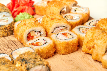 Set of various sushi rolls on a board. Close-up, selective focus