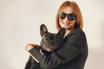 Woman with dog. Lady in a black suit. Girl play with bulldog.