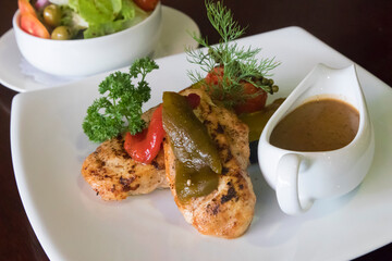 Grilled chicken breast with pumpkin, gravy and a mixed salad