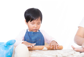 Chinese little girl learning to press dumpling wrappers in front of white background