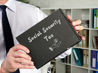 Financial concept meaning Social Security Tax with phrase on the piece of paper.