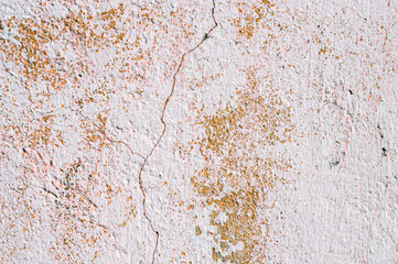 Grunge background of cracked peeling walls with peeled putty in beige tones