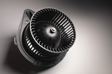Heater motor. A spare part for an automobile heating system on a black-gray gradient background. Low key high contrast