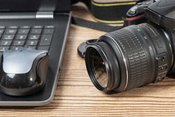 Dslr photo camera and laptop on desk table