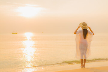 Portrait beautiful young asian woman relax smile leisure around outdoor sea beach ocean at sunset time