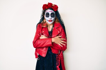 Woman wearing day of the dead costume over white shaking and freezing for winter cold with sad and shock expression on face