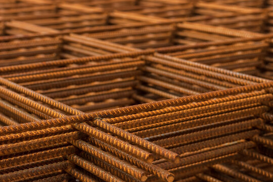 Group of rusty reinforced concrete construction steel net piles on outdoor ground. Selective focus and blurred for copy space.