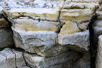 mountain textures of stones with interlayers of gypsum, colored quartz, clay, sand and other layers of various ores, with different textures, color and density, in gypsum ore quarry.