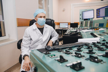 Operator engineer in medical mask control panel of nuclear thermal power plant