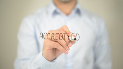 Accredited, man writing on transparent screen
