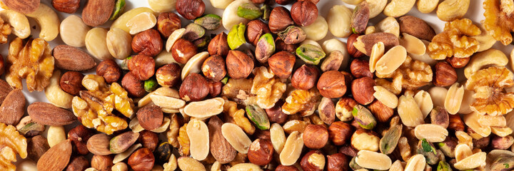Nuts variety panoramic banner. A mix of peanuts, hazelnuts, walnuts, pistachios and almonds, top shot