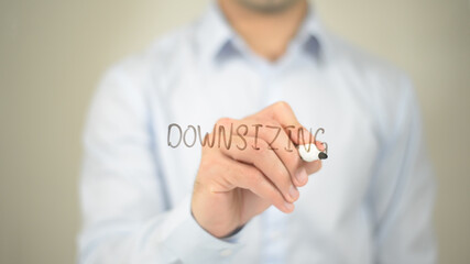 Downsizing , man writing on transparent screen